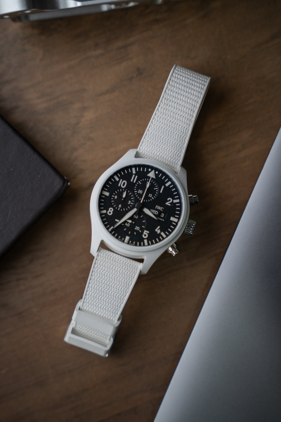 White watch with black dial on a wooden surface
