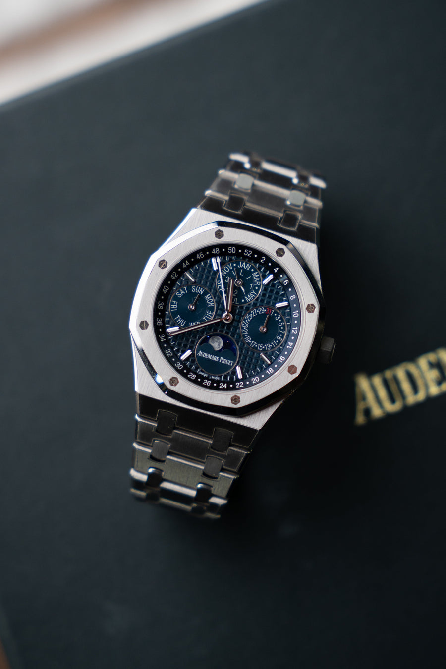 Luxury watch on a dark surface with 'Audemars Piguet' branding.
