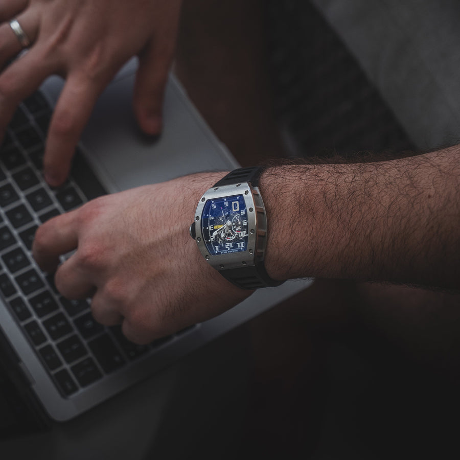 Person typing on a laptop with a watch on their wrist