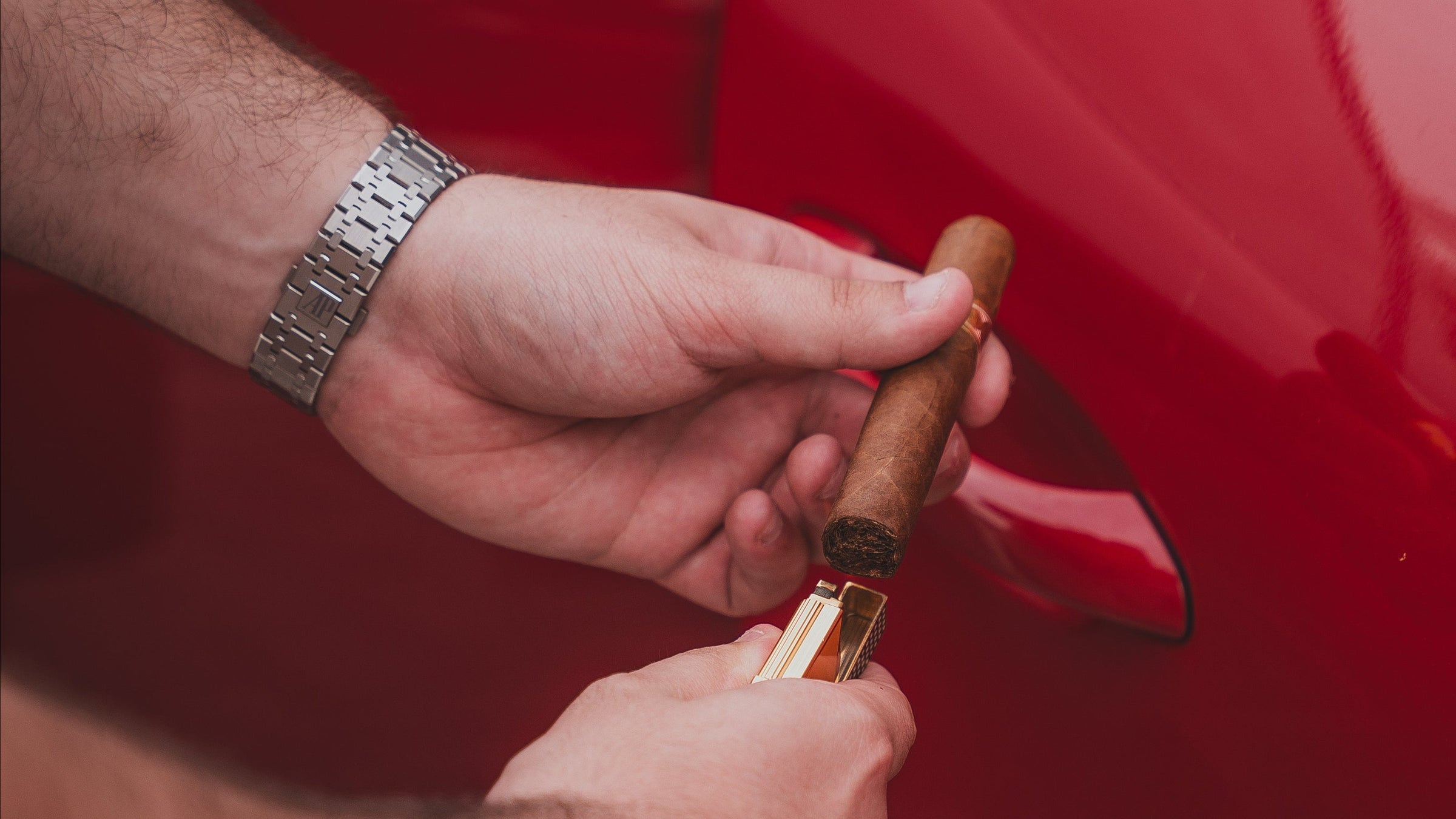 Person using a car door lock pick tool on a red car door.